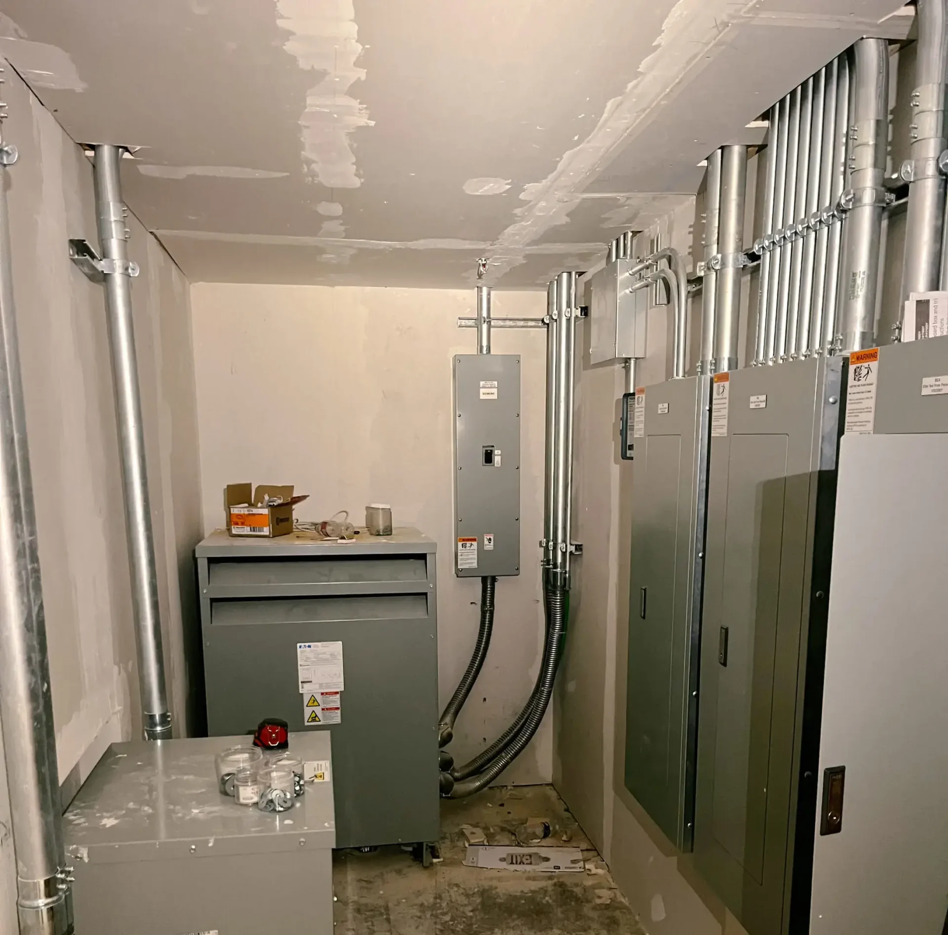 Electrical room with panels and conduits.